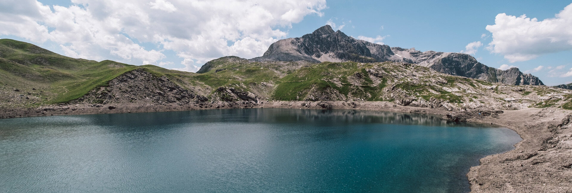 Blauer Bergsee vor Bergpanorama