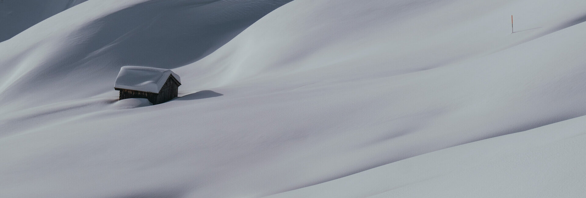 Kleine Hütte in verschneiter Berglandschaft