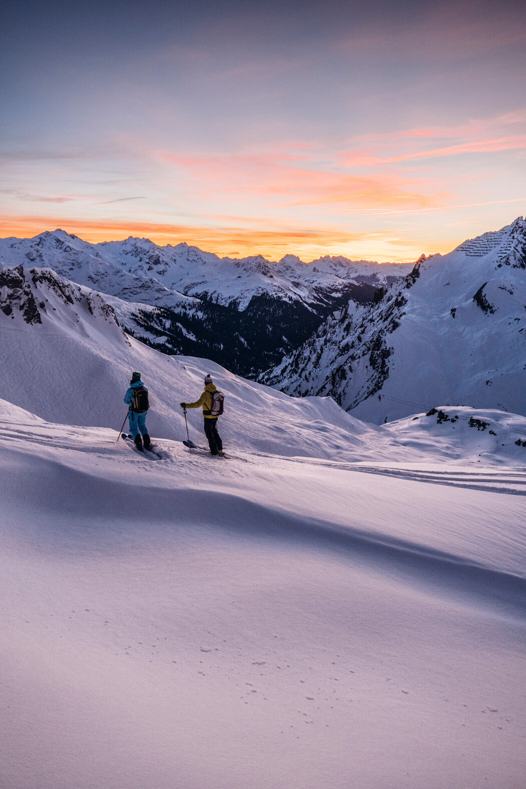 Zwei Skifahrer vor Bergpanorama